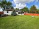 Well-maintained backyard with a lush green lawn, a privacy fence, and a charming sunroom at 1513 Ashley Dr, Lebanon, IN 46052