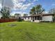 Expansive backyard featuring a lush green lawn, a privacy fence, a charming sunroom, and mature trees at 1513 Ashley Dr, Lebanon, IN 46052