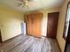 Bedroom with wood-look floors, a murphy bed, a ceiling fan, and natural light from the window at 1513 Ashley Dr, Lebanon, IN 46052