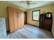 Bedroom with wood-look floors, a murphy bed, a ceiling fan, and natural light from the window at 1513 Ashley Dr, Lebanon, IN 46052