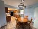 Cozy dining room with wood-style flooring, a wooden table, and views into the kitchen at 1513 Ashley Dr, Lebanon, IN 46052