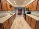 Open-concept kitchen with wood cabinets and granite countertops extends into the dining area, perfect for entertaining at 1513 Ashley Dr, Lebanon, IN 46052