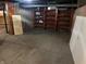 Unfinished basement with concrete flooring and walls and wooden shelving at 1618 California St, Columbus, IN 47201