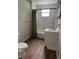 Bathroom featuring a toilet, sink, cabinet, a bathtub, white tile, and a polka dot shower curtain at 1618 California St, Columbus, IN 47201