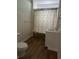 A bathroom featuring a toilet, sink, cabinet, white tiling, and a shower curtain at 1618 California St, Columbus, IN 47201