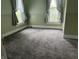 Bright bedroom featuring neutral gray carpeting and windows with patterned curtains at 1618 California St, Columbus, IN 47201