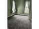 A cozy bedroom featuring plush gray carpeting and large windows with decorative curtains at 1618 California St, Columbus, IN 47201