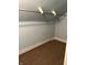 A closet space with blue walls, brown carpet, a white baseboard, and a metal clothing rack at 1618 California St, Columbus, IN 47201