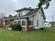 Charming home with white siding, well-maintained lawn, chain link fence and detached garage at 1618 California St, Columbus, IN 47201