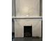 Close-up view of a white brick fireplace with a wood-burning insert and logs at 1618 California St, Columbus, IN 47201