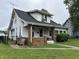 Traditional home with dark roof, covered porch, small yard, and chain link fence at 1618 California St, Columbus, IN 47201