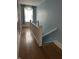 A hallway with hardwood floors, blue walls, a banister, and a window with a blue curtain at 1618 California St, Columbus, IN 47201