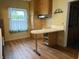 Bright kitchen with wood look flooring, light wood cabinets, peninsula bar and small window at 1618 California St, Columbus, IN 47201