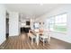 Bright dining area with laminate floors, a dining table with chairs and a bench, and views into the kitchen at 17951 Paula Walk, Westfield, IN 46074
