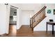 Bright entryway featuring wood floors, stairs with wooden railing, and a view into an adjacent room at 17951 Paula Walk, Westfield, IN 46074
