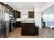 Modern kitchen with laminate floors, dark cabinets, stainless steel appliances, and a functional center island at 17951 Paula Walk, Westfield, IN 46074