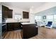 Modern kitchen with laminate floors, dark cabinets, stainless steel appliances, and a center island with a light countertop at 17951 Paula Walk, Westfield, IN 46074