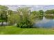 View of a lush backyard with a tranquil pond and mature trees at 1966 Freedom Ct, Greenfield, IN 46140