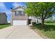 Charming two-story home featuring a brick facade, attached two-car garage, and lush front yard landscaping at 1966 Freedom Ct, Greenfield, IN 46140
