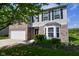 Well-maintained two-story home featuring a brick facade, bay window, and manicured landscaping at 1966 Freedom Ct, Greenfield, IN 46140