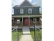 Charming two-story home featuring a bright red front door, a covered porch, and a fenced front yard at 209 N Beville N Ave, Indianapolis, IN 46201