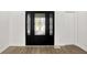 Elegant entryway featuring wood floors, decorative front door with sidelights and a white closet door at 213 S State Ave, Indianapolis, IN 46201