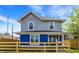 Charming two-story home with a blue-and-gray exterior, complemented by a well-maintained yard and wood fence at 213 S State Ave, Indianapolis, IN 46201