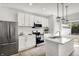 Bright kitchen featuring stainless steel appliances, white cabinets, a kitchen island, and backyard access at 213 S State Ave, Indianapolis, IN 46201