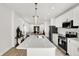 Modern kitchen with white cabinets, stainless steel appliances, quartz countertops, and stylish pendant lighting at 213 S State Ave, Indianapolis, IN 46201