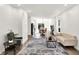 Bright, open-concept living room with hardwood floors and a modern rug that flows into the kitchen at 213 S State Ave, Indianapolis, IN 46201