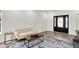 Bright living room with light-colored sofa, decorative rug, modern coffee table, and a decorative front door at 213 S State Ave, Indianapolis, IN 46201
