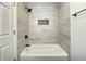 Newly renovated bathroom showcasing a tiled shower/tub combo and a convenient storage niche at 2141 Napoleon St, Indianapolis, IN 46203