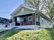 Charming bungalow with brick accents and a welcoming front porch on a well-manicured lawn at 2141 Napoleon St, Indianapolis, IN 46203