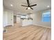 Open-concept living room area with new laminate floors, neutral walls and a modern ceiling fan at 2141 Napoleon St, Indianapolis, IN 46203