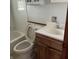 Modest bathroom featuring a toilet, tub, and sink with wood-stained cabinets at 2621 N Tacoma Ave, Indianapolis, IN 46218