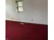 This bedroom features red carpet flooring, natural light, and white walls at 2621 N Tacoma Ave, Indianapolis, IN 46218