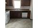The kitchen features wood cabinets, a double basin sink and white appliances at 2621 N Tacoma Ave, Indianapolis, IN 46218