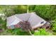 An aerial view shows a beautiful home featuring a three-car garage, brick accents, and mature trees at 265 Monticello Dr, Greenwood, IN 46142