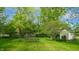 Lush backyard featuring mature trees, manicured lawn, and a storage shed, providing ample outdoor space at 265 Monticello Dr, Greenwood, IN 46142