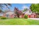Charming brick home featuring an attached two car garage, manicured lawn, and mature trees at 265 Monticello Dr, Greenwood, IN 46142