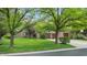 Charming brick home with a well-manicured lawn, mature trees, and a three-car garage at 265 Monticello Dr, Greenwood, IN 46142