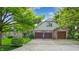Traditional home featuring three-car garage, mature trees, and brick accents at 265 Monticello Dr, Greenwood, IN 46142