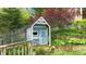 Charming playhouse featuring a light blue exterior and white trim in a lush backyard setting at 265 Monticello Dr, Greenwood, IN 46142