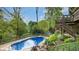 Inviting backyard with a refreshing in-ground pool, wooden deck, and lush garden surroundings at 265 Monticello Dr, Greenwood, IN 46142