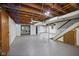 Unfinished basement with exposed ductwork, painted floors, and visible plumbing lines, offering potential at 311 Duffey St, Plainfield, IN 46168