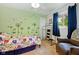 Charming bedroom featuring bright floral bedding, butterfly decals, and a cozy armchair by the window at 349 Clark Ave, Beech Grove, IN 46107
