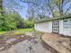 Detached garage featuring a white exterior, side window, and black iron security door at 3516 Janet Dr, Indianapolis, IN 46218