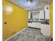 Kitchen featuring gray floors, light cabinets, a window, and bright yellow walls at 3516 Janet Dr, Indianapolis, IN 46218
