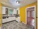 Kitchen featuring gray floors, light cabinets, a window, and bright yellow walls at 3516 Janet Dr, Indianapolis, IN 46218