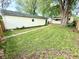 The yard has green grass, a sidewalk, and a one-car detached garage at 417 S Oakland Ave, Indianapolis, IN 46201